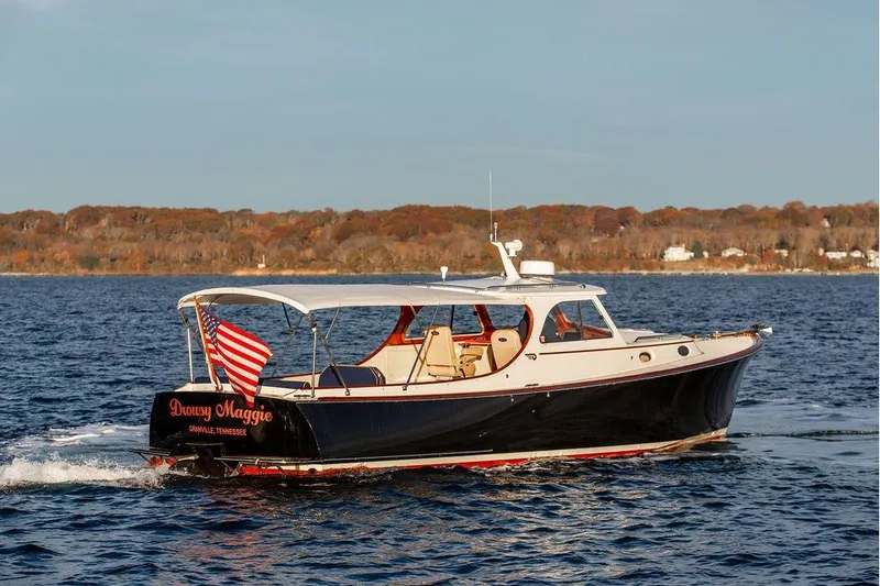 The Image of 2000 Hinckley Picnic Boat Classic cruising on a scenic lake with autumn foliage. - 0