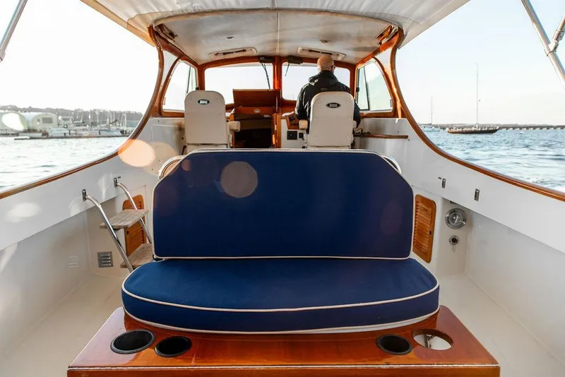 Slide: The Image of 2001 Hinckley Ya Picn boat interior with blue seating and wooden accents on the water. - 14
