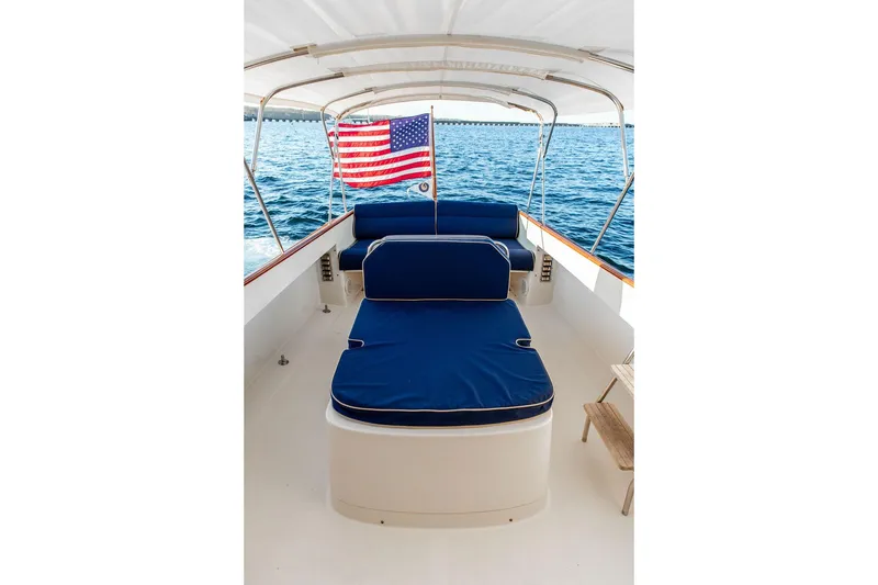 Slide: The Image of 2001 Hinckley Ya Picn boat interior with blue seating, overlooking calm waters. - 16