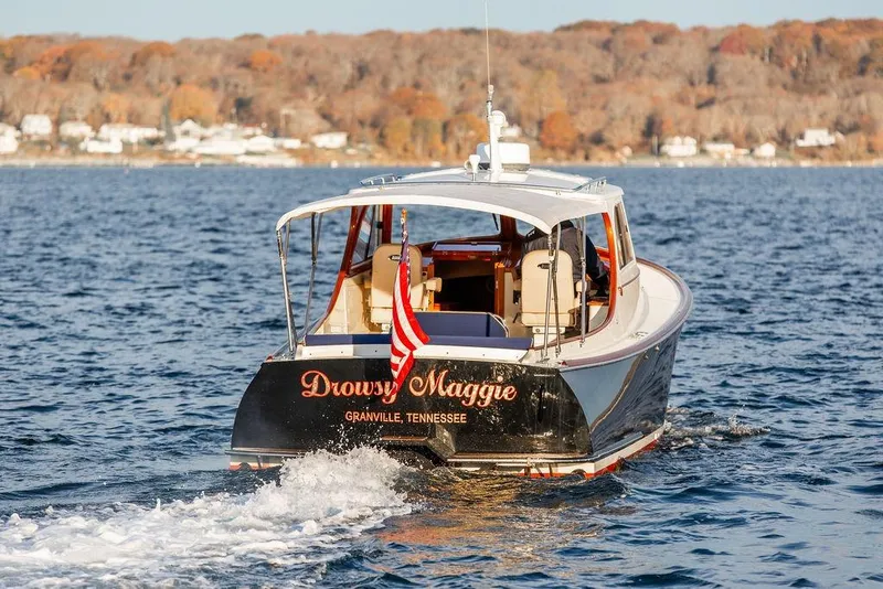 Slide: The Image of Close-up of a 2001 Hinckley Ya Picn boat emblem on a wooden surface. - 33