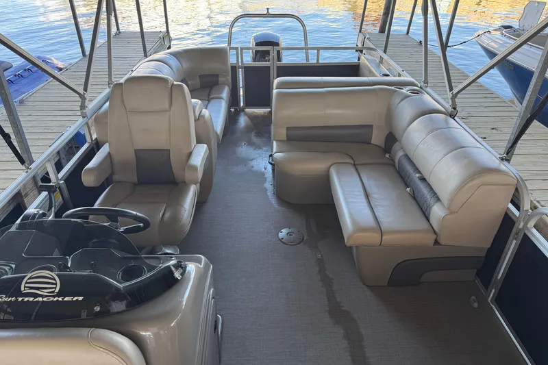 Slide: The Image of 2020 Sun Tracker Party Barge 22 DLX helm with beige captain's chair and dashboard controls. - 11