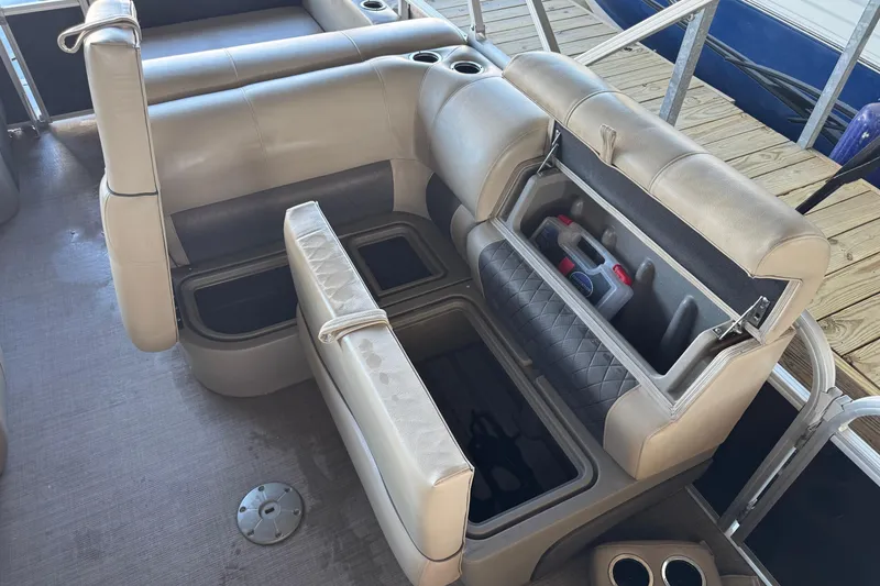 Slide: The Image of 2020 Sun Tracker Party Barge 22 DLX, beige seating with storage, docked on wooden pier. - 16