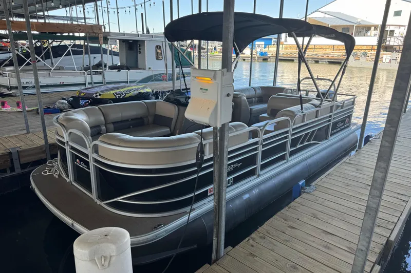 Slide: The Image of 2020 Sun Tracker Party Barge 22 DLX pontoon boat docked with seating and canopy. - 4