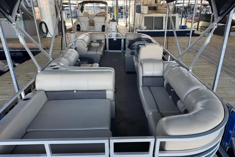 Slide: The Image of 2020 Sun Tracker Party Barge 22 DLX with spacious seating and cup holders, docked by the water. - 8