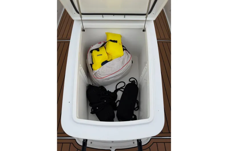 Slide: The Image of Open storage compartment on 2018 Sea Hunt Gamefish 30 Coffin Box with life jackets and gear. - 10