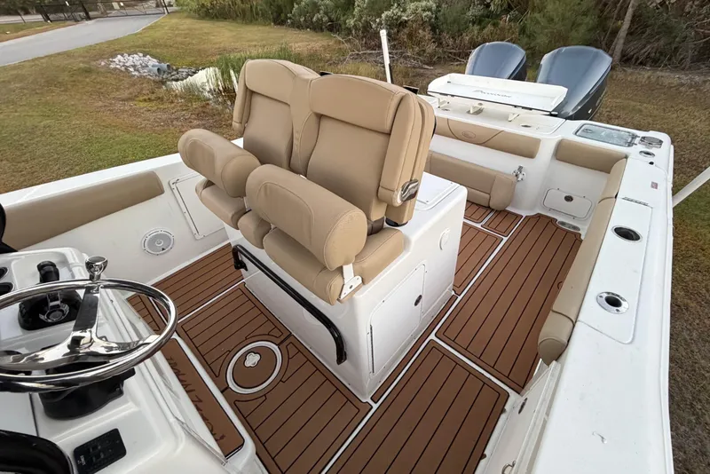 Slide: The Image of 2018 Sea Hunt Gamefish 30 Coffin Box boat interior with tan seating and wood-style flooring. - 17