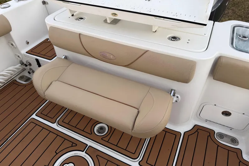 Slide: The Image of 2018 Sea Hunt Gamefish 30 Coffin Box interior with tan seating and teak-style flooring. - 26