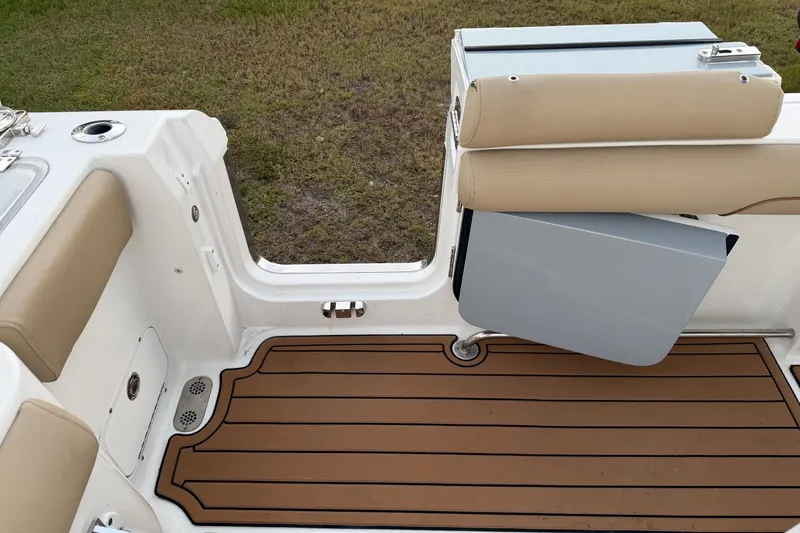 Slide: The Image of 2018 Sea Hunt Gamefish 30 Coffin Box interior with cushioned seating and teak-style flooring. - 29