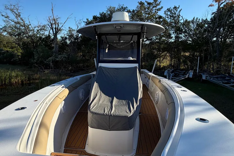 Slide: The Image of 2018 Sea Hunt Gamefish 30 Coffin Box boat with covered seating, surrounded by trees. - 59
