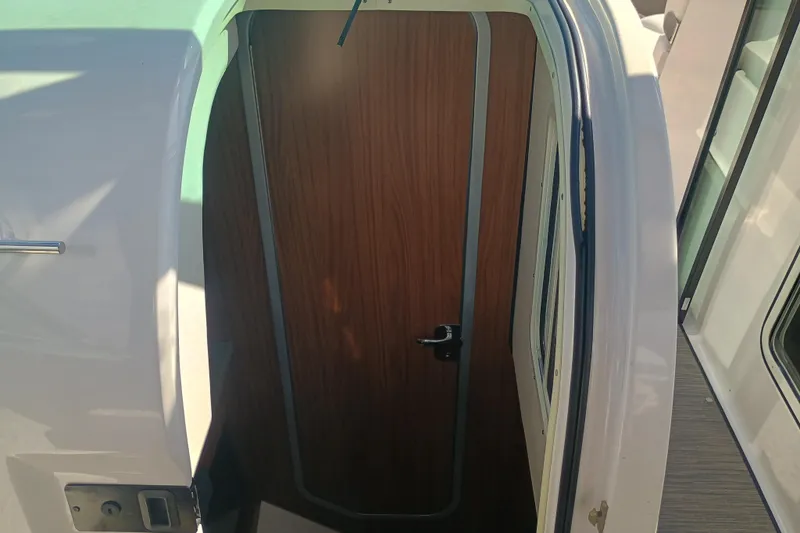 Slide: The Image of 2019 Four Winns H350 OB cabin door with wooden finish and sleek design. - 15