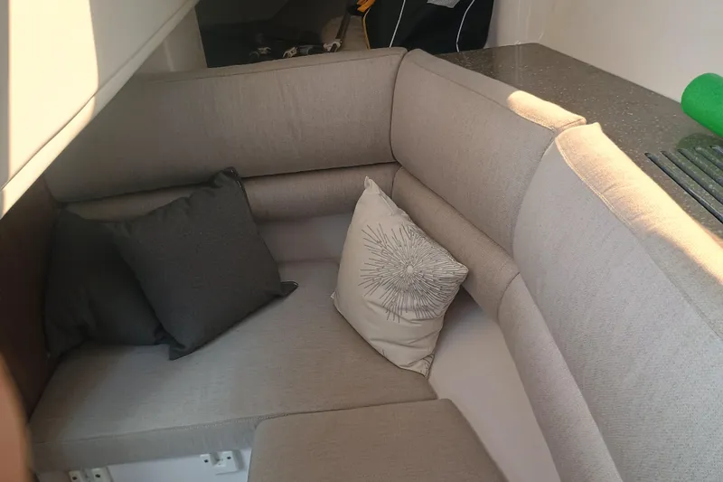 Slide: The Image of 2019 Four Winns H350 OB cabin interior with beige seating and decorative pillows. - 24