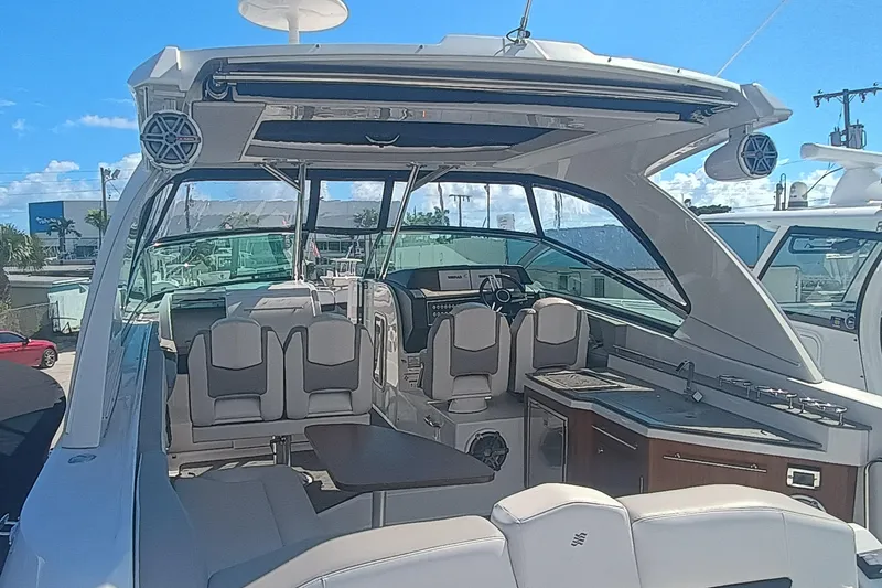 Slide: The Image of 2019 Four Winns H350 OB boat interior with seating, table, and helm station. - 30