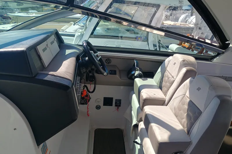 Slide: The Image of 2019 Four Winns H350 OB boat interior with steering wheel and dual seats. - 9