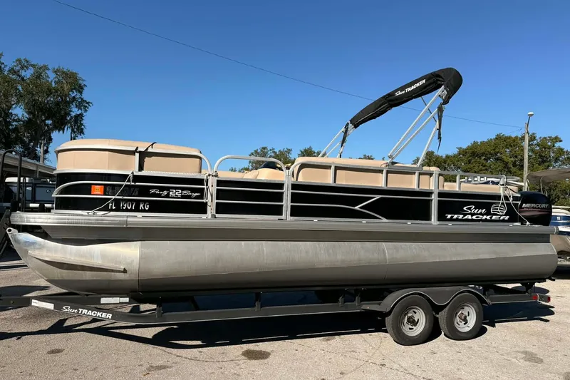 The Image of 2017 Sun Tracker Party Barge 22 DLX pontoon boat on trailer, sunny day. - 0