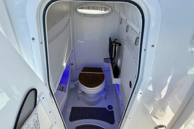 Slide: The Image of 2026 Sea Hunt Ultra 255 SE boat interior with compact marine toilet and storage. - 13
