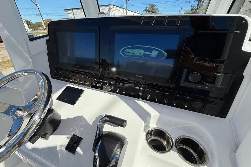 Slide: The Image of 2026 Sea Hunt Ultra 255 SE boat dashboard with Garmin displays and controls. - 17