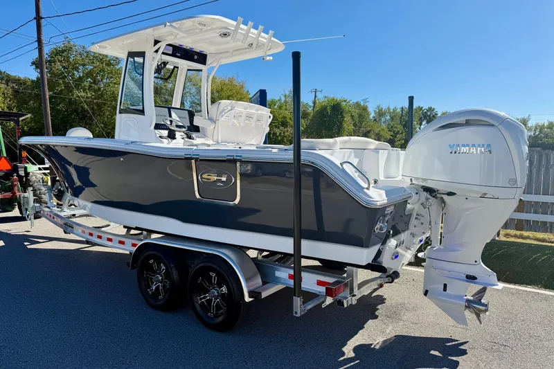 Slide: The Image of 2026 Sea Hunt Ultra 255 SE boat on trailer with Yamaha engine, parked outdoors. - 2