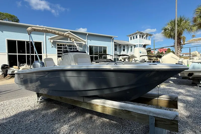 Slide: The Image of 2026 Scout 188 Sportfish boat displayed outdoors at a marina with blue buildings. - 4