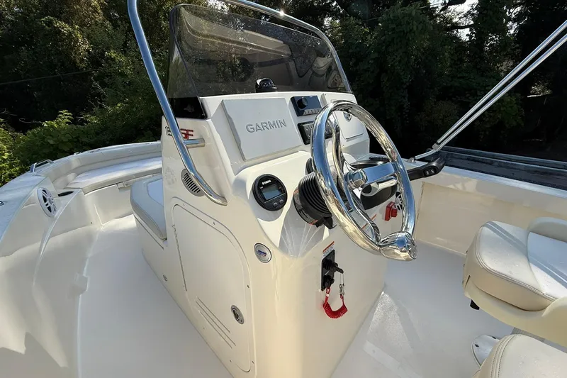 Slide: The Image of 2026 Scout 188 Sportfish boat helm with Garmin navigation system and chrome steering wheel. - 7