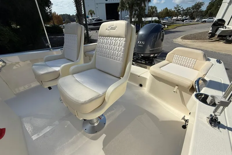 Slide: The Image of 2026 Scout 188 Sportfish boat interior with cushioned seating and outboard motor. - 9
