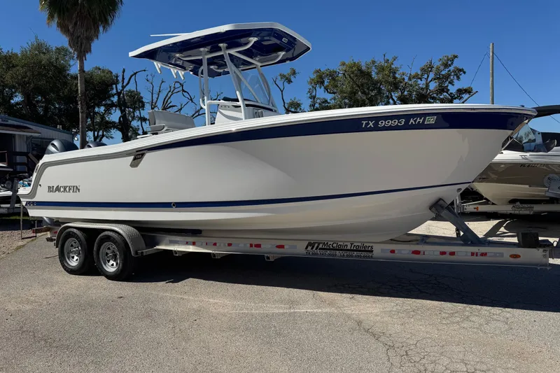 The Image of 2021 Blackfin 252 CC boat on trailer, parked outdoors under clear sky. - 0