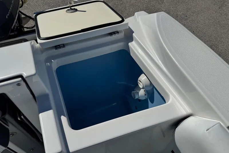 Slide: The Image of Open storage compartment on 2021 Blackfin 252 CC boat, featuring a blue interior. - 11