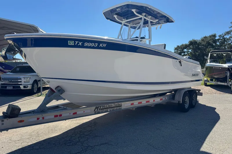Slide: The Image of 2021 Blackfin 252 CC boat on trailer, parked outdoors, side view. - 2