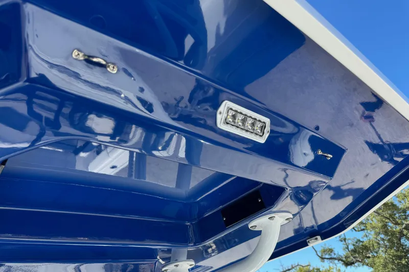 Slide: The Image of 2021 Blackfin 252 CC boat detail, featuring a sleek blue finish and mounted light. - 36