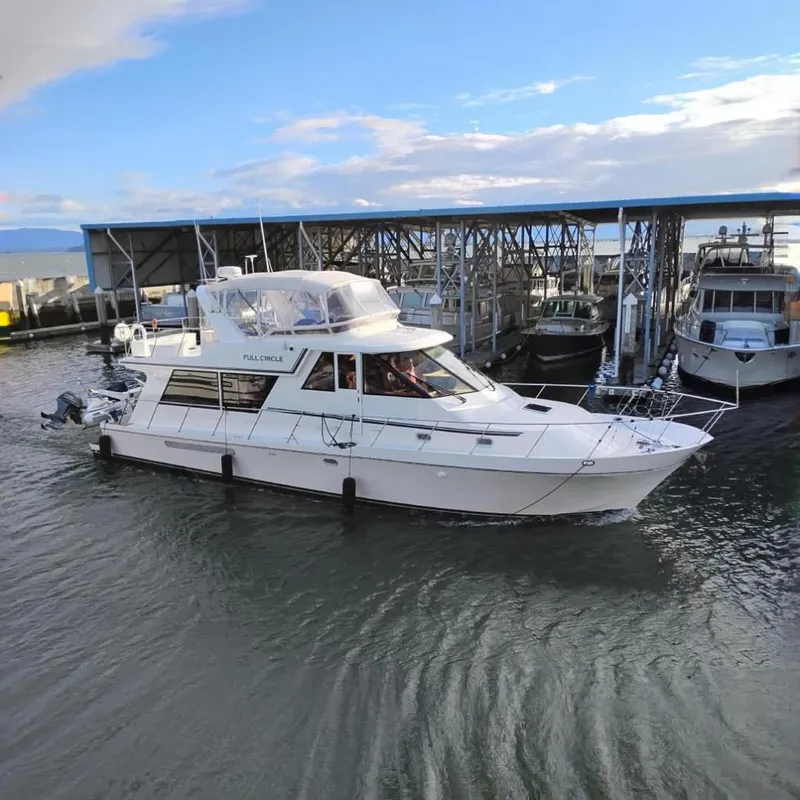 The Image of 2002 Canoe Cove 50 Pilothouse Motor Yacht docked at marina under blue sky. - 0