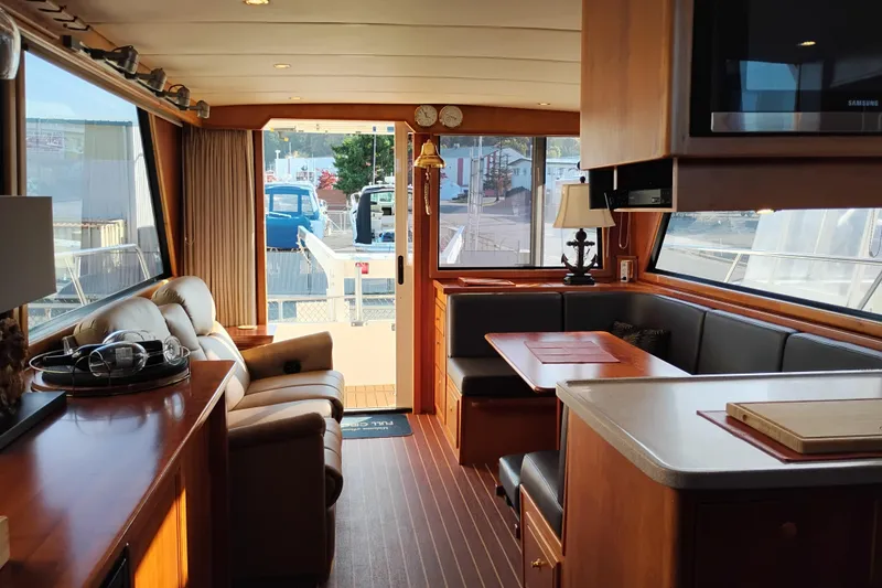 Slide: The Image of Interior of 2002 Canoe Cove 50 Pilothouse Motor Yacht, featuring luxurious seating and dining area. - 16