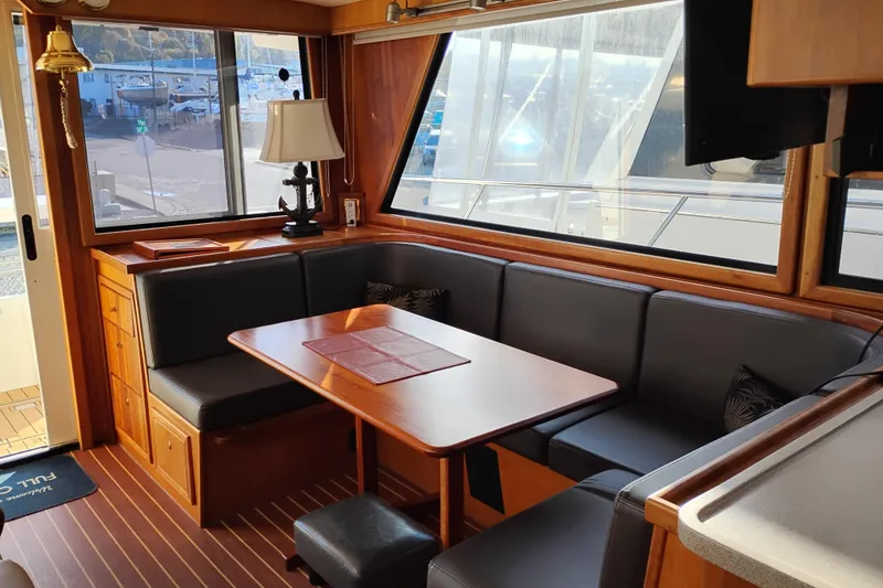 Slide: The Image of Interior of 2002 Canoe Cove 50 Pilothouse Motor Yacht with dining area and large windows. - 19