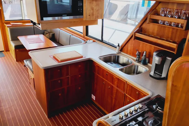 Slide: The Image of Luxurious 2002 Canoe Cove 50 Pilothouse Motor Yacht interior with modern kitchen and dining area. - 22