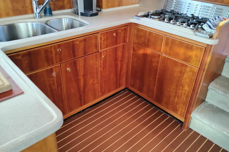 Slide: The Image of Kitchen area of 2002 Canoe Cove 50 Pilothouse Motor Yacht with wood cabinets and stove. - 23