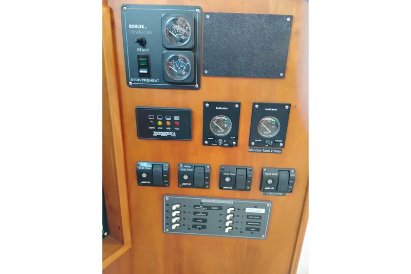 Slide: The Image of Control panel of 2002 Canoe Cove 50 Pilothouse Motor Yacht with gauges and switches. - 38
