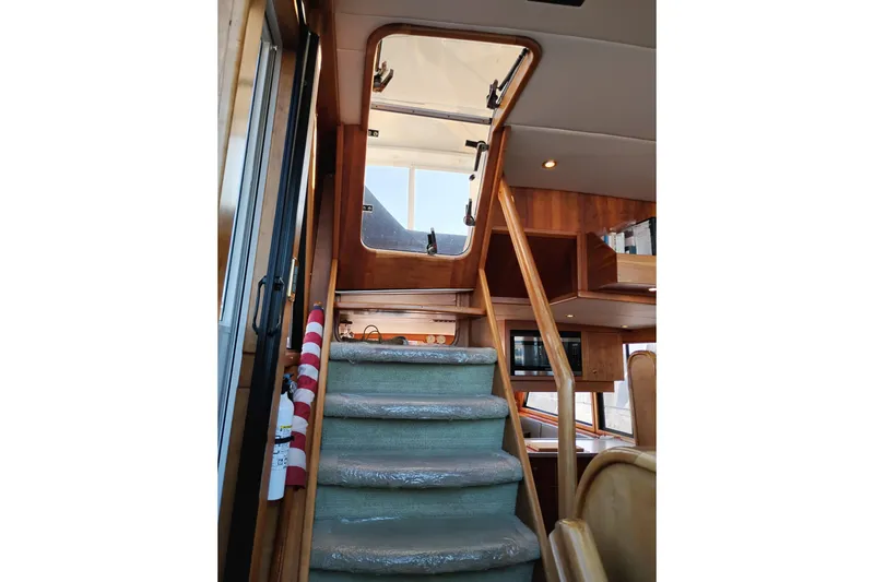 Slide: The Image of Interior stairs of 2002 Canoe Cove 50 Pilothouse Motor Yacht, featuring wood accents and carpeted steps. - 44