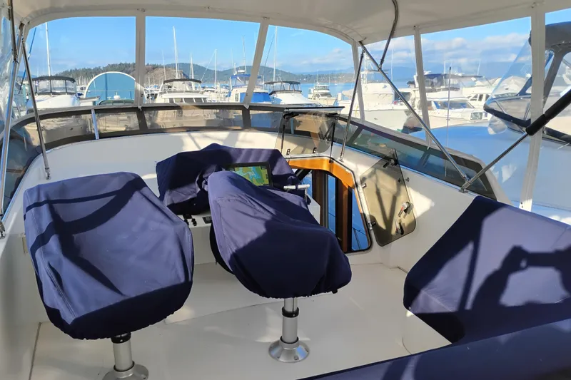 Slide: The Image of Pilothouse of 2002 Canoe Cove 50 Motor Yacht with covered seats, marina view. - 49