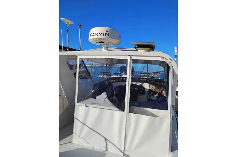 Slide: The Image of Canoe Cove 50 Pilothouse Motor Yacht, 2002, with Garmin radar, docked under clear blue sky. - 55