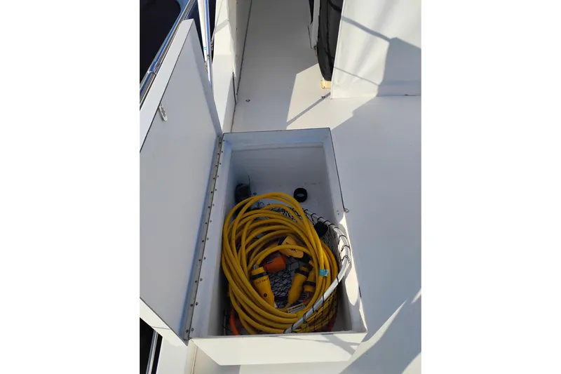 Slide: The Image of Storage compartment on 2002 Canoe Cove 50 Pilothouse Motor Yacht with yellow cables. - 58