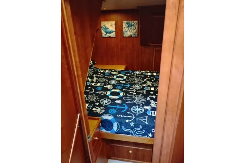 Slide: The Image of Cozy cabin interior of 2002 Canoe Cove 50 Pilothouse Motor Yacht with nautical-themed bedding. - 62