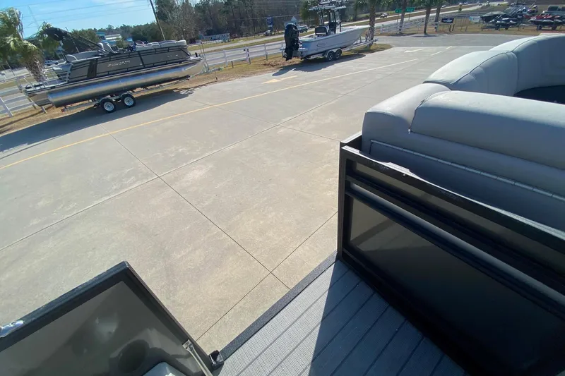 Slide: The Image of 2024 Starcraft SLS 3 pontoon boat on trailer in parking lot. - 20