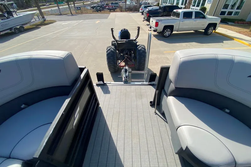 Slide: The Image of 2024 Starcraft SLS 3 boat interior with gray seating, parked on a concrete lot. - 12