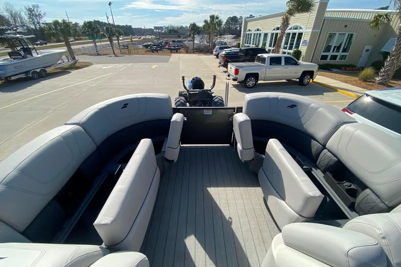 Slide: The Image of 2024 Starcraft SLS 3 pontoon boat with spacious seating, parked outdoors. - 13