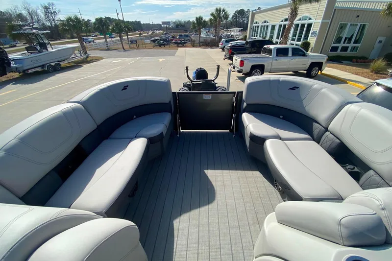 Slide: The Image of 2024 Starcraft SLS 3 pontoon boat with spacious seating, parked outdoors. - 15