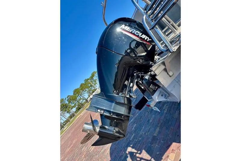 Slide: The Image of 2023 Harris Cruiser 230 with Mercury outboard motor, parked on brick pavement. - 10