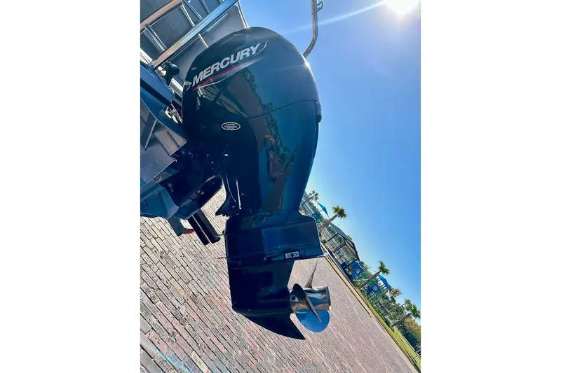 Slide: The Image of 2023 Harris Cruiser 230 with Mercury outboard motor in sunny outdoor setting. - 12