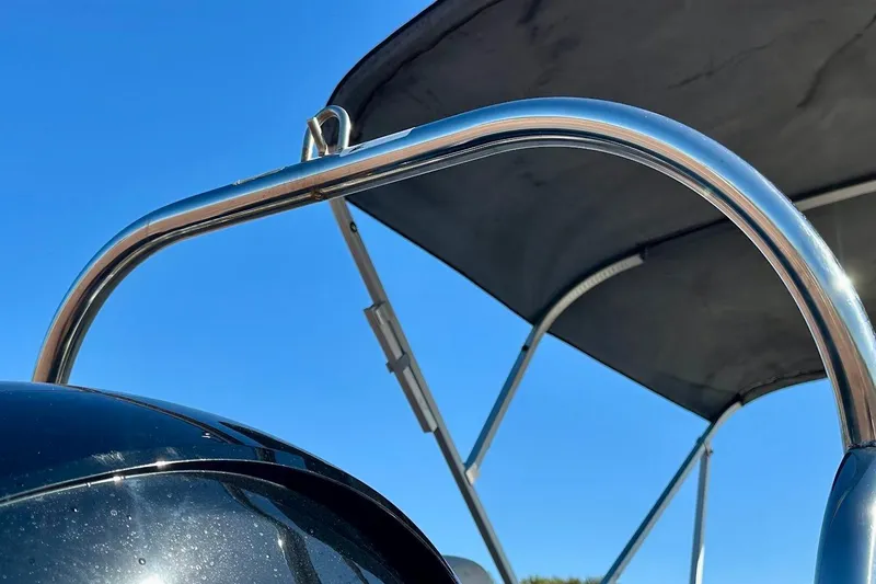 Slide: The Image of 2023 Harris Cruiser 230 boat with sleek metal frame and canopy against blue sky. - 14