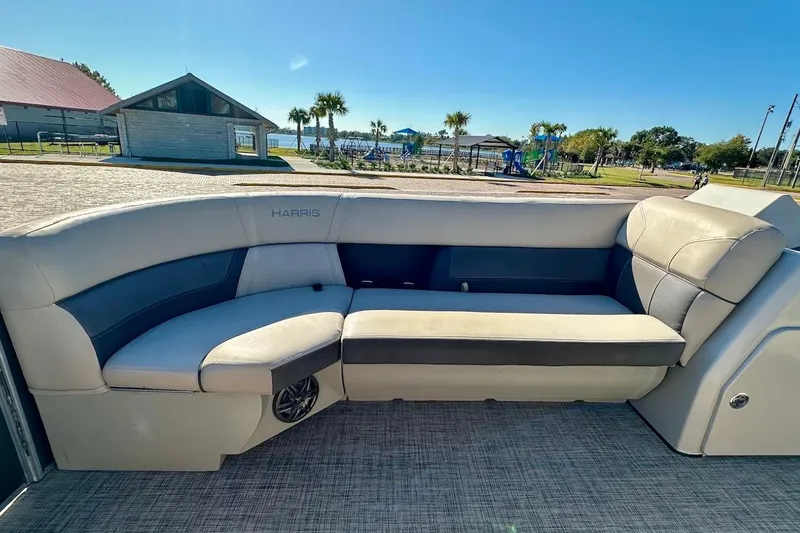 Slide: The Image of 2023 Harris Cruiser 230 boat interior with plush seating and scenic outdoor view. - 16