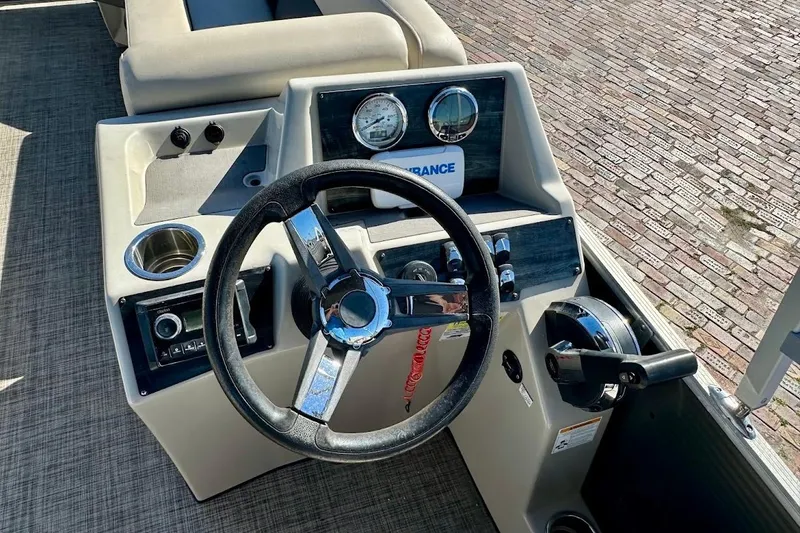 Slide: The Image of 2023 Harris Cruiser 230 boat dashboard with steering wheel and controls. - 18
