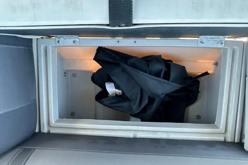 Slide: The Image of Storage compartment in 2023 Harris Cruiser 230 boat with black fabric inside. - 27