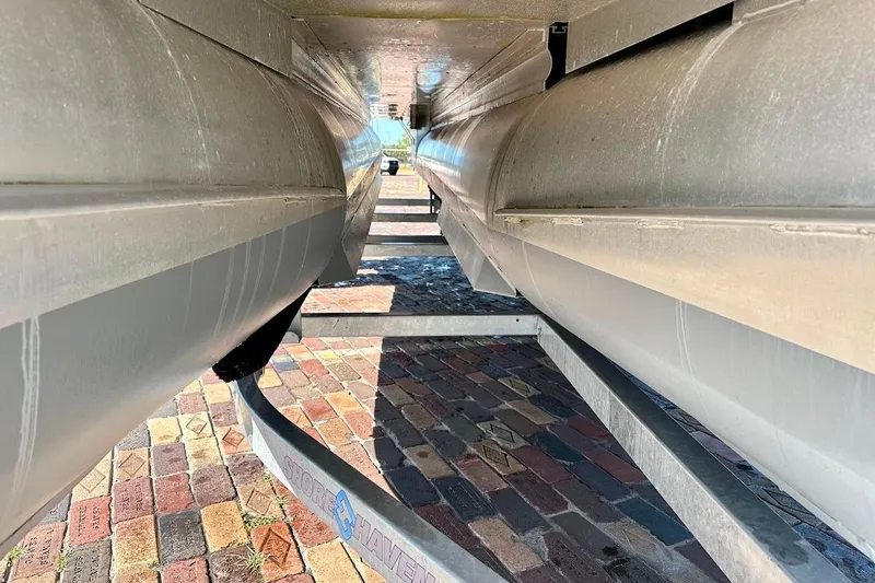 Slide: The Image of Underneath view of a 2023 Harris Cruiser 230 pontoon boat on a trailer. - 6